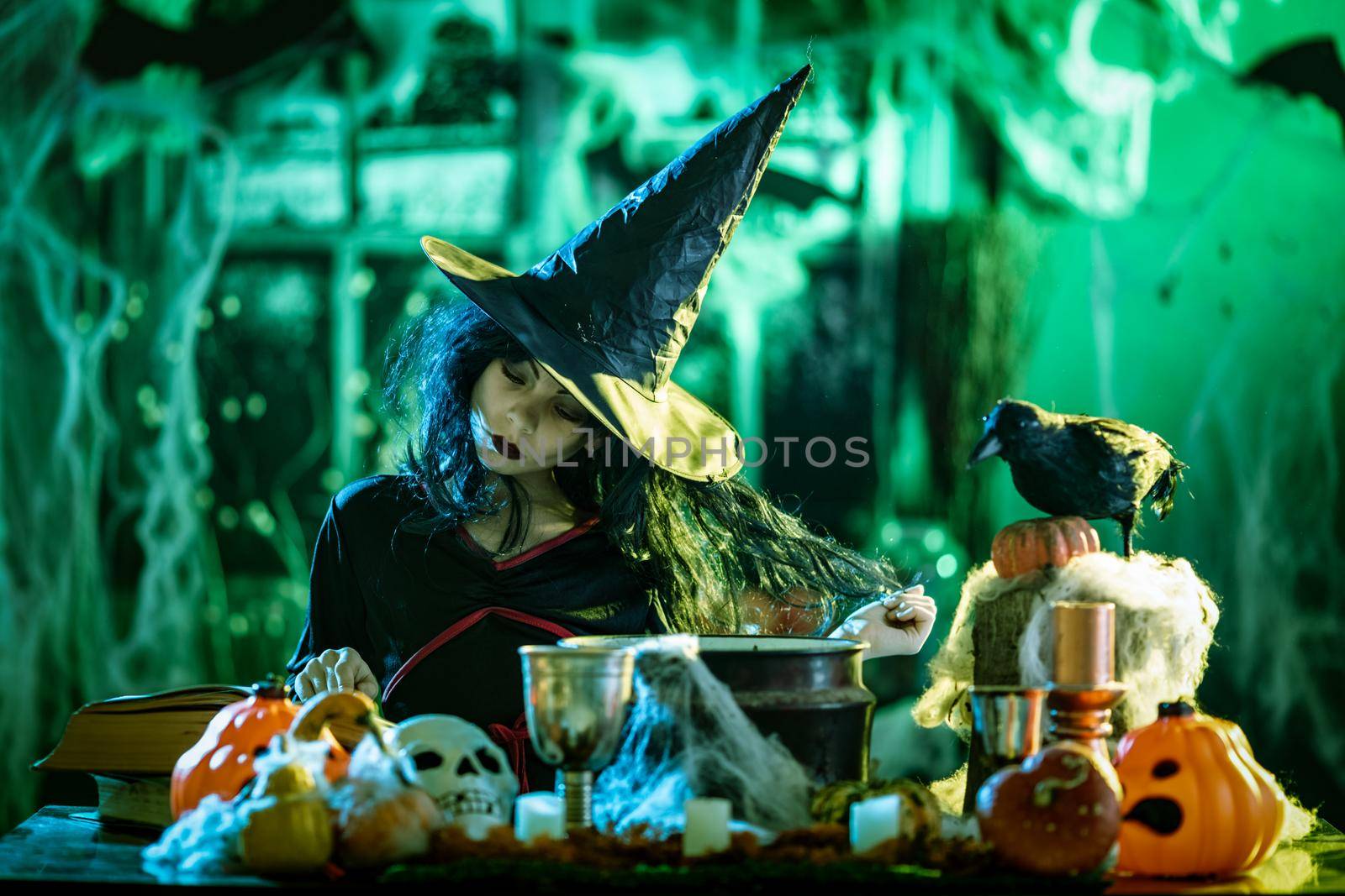 Young witch with awfully face reading recipes of magic drink in creepy surroundings and smoky background.
