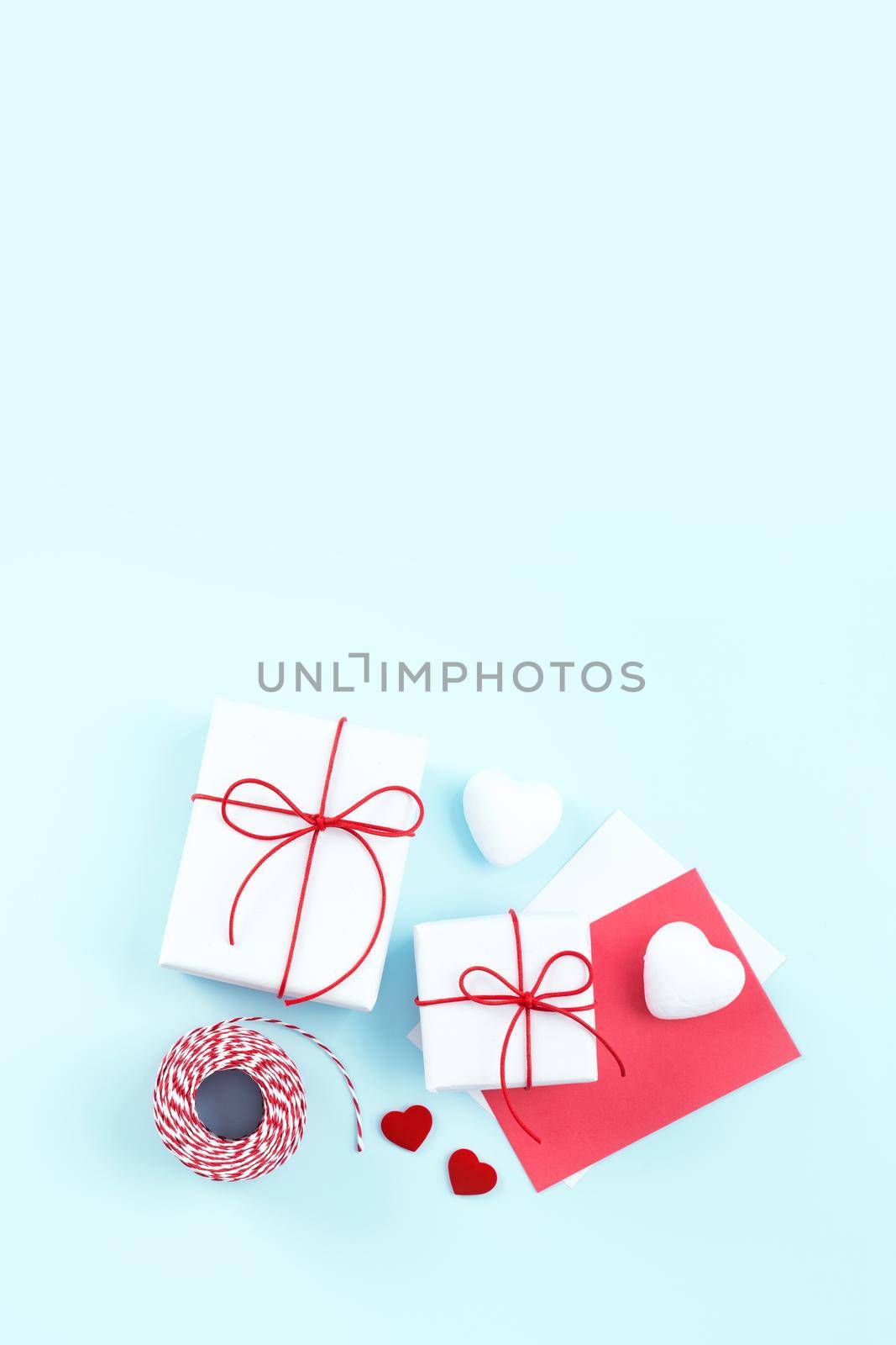 Valentine's Day, Mother's day handmade gift design concept - Wrapped gift box isolated on pastel light blue color background, flat lay, top view.