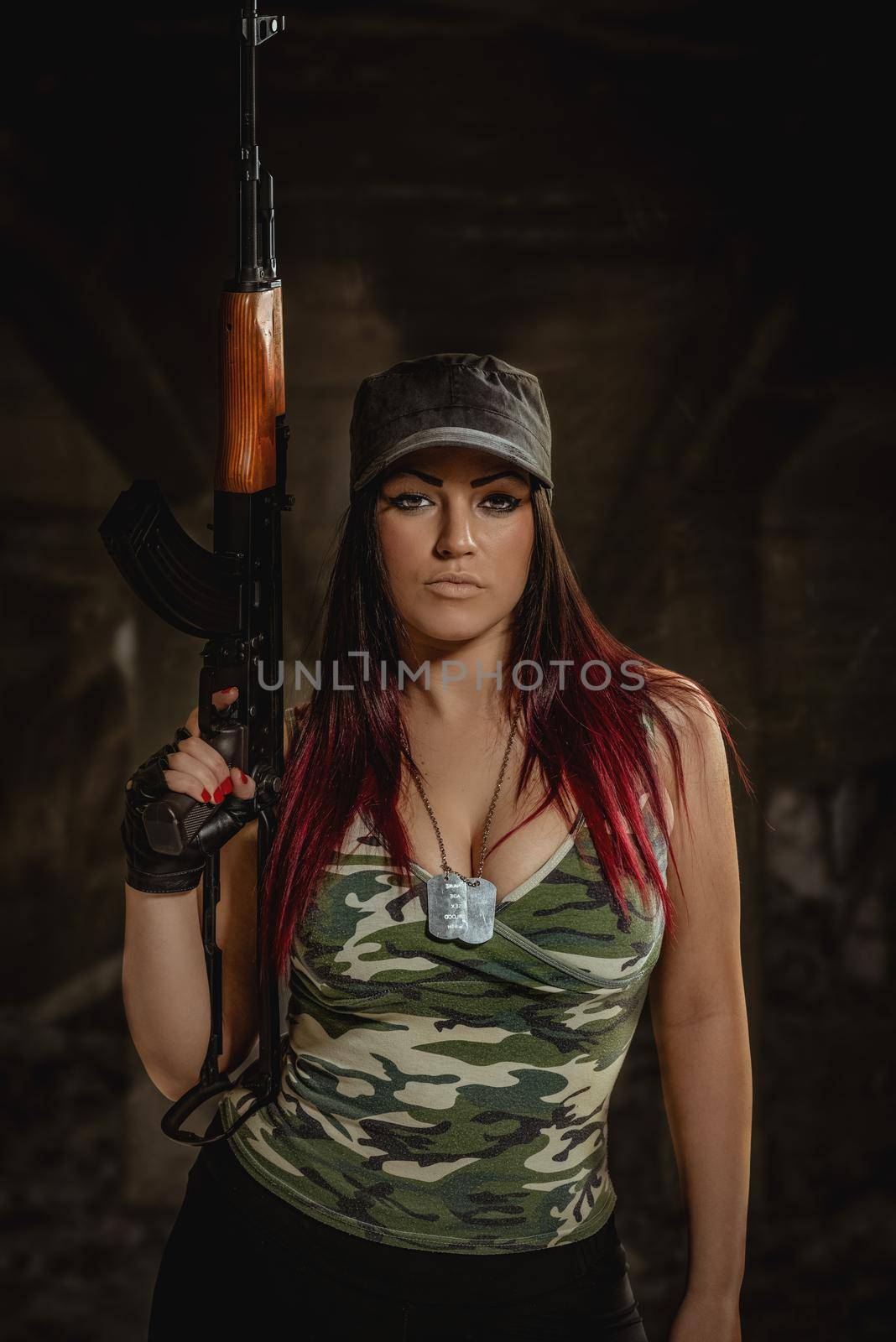 Young beautiful military woman holding rifle.