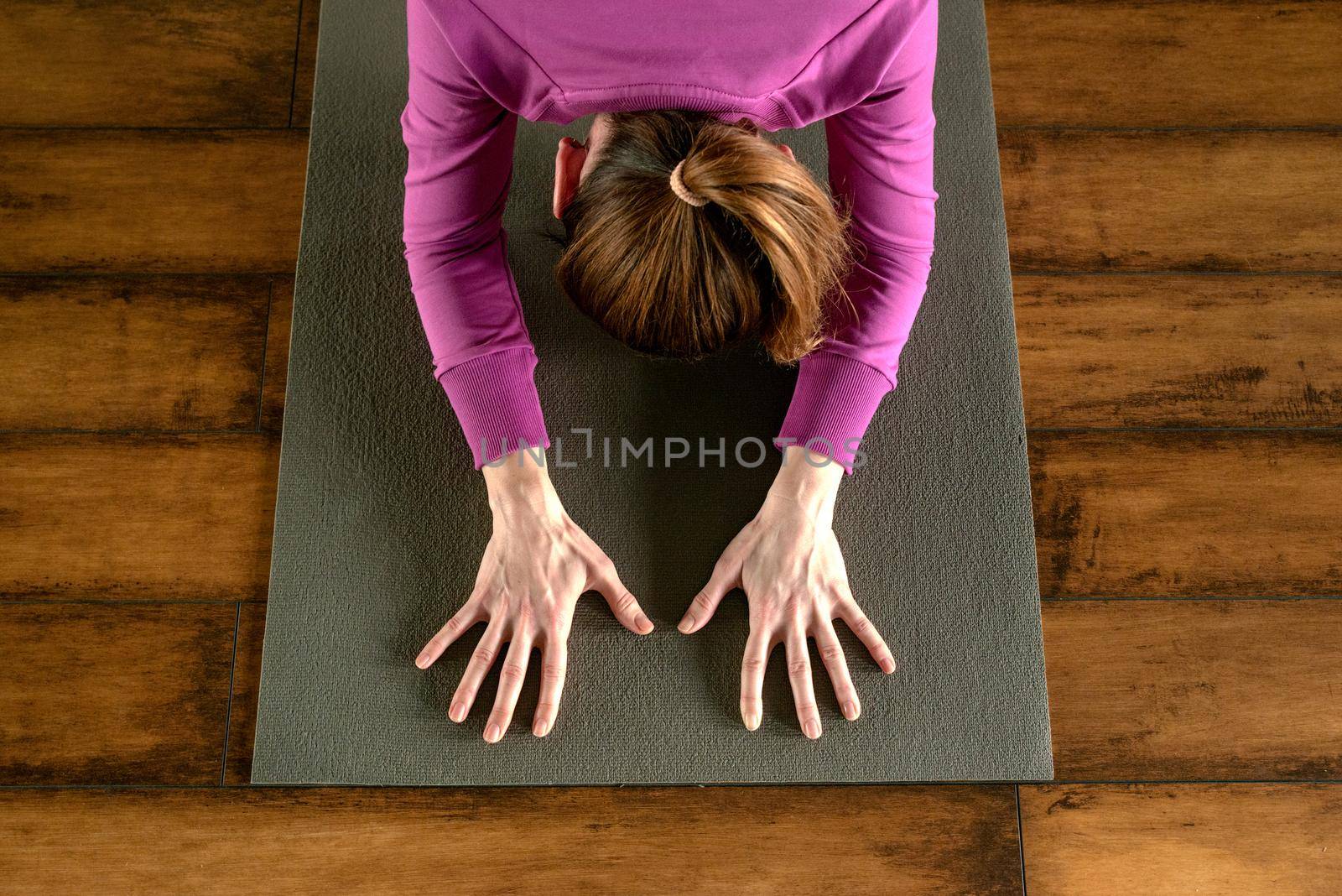 Portrait of a beautiful young woman sitting in yoga pose at the beach