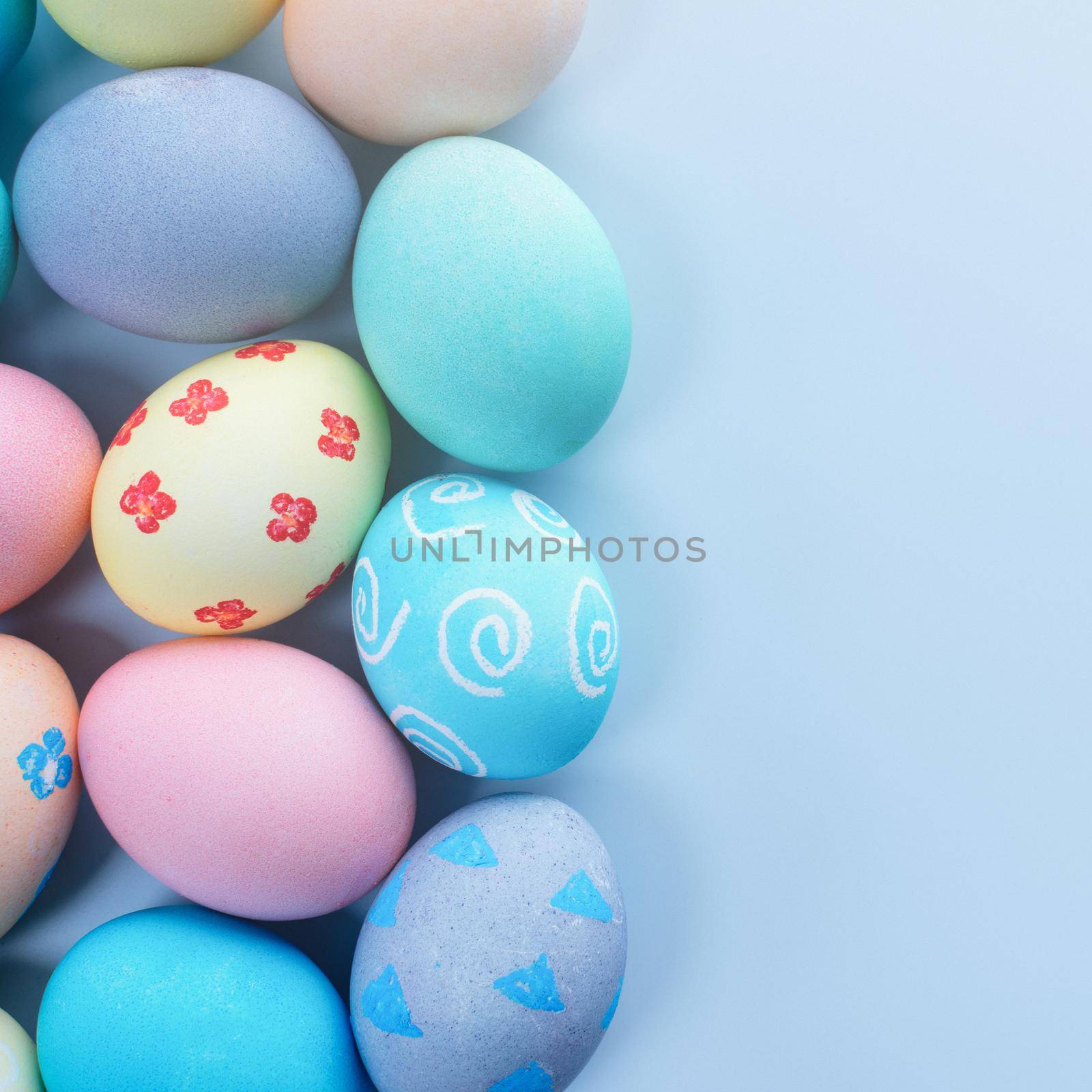 Colorful Easter hunting eggs dyed by colored water with beautiful pattern on pastel blue background, design concept of holiday, top view, copy space. by ROMIXIMAGE