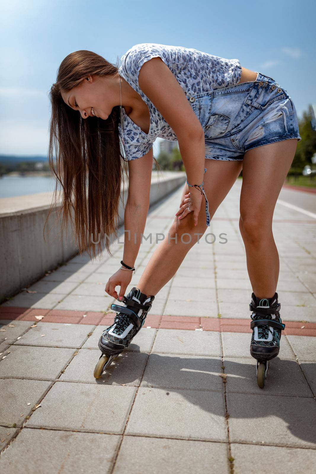 A beautiful smiling young Filipino woman having happy time during the roller blanding and enjoying on the city rivershore on a beautiful summer day.