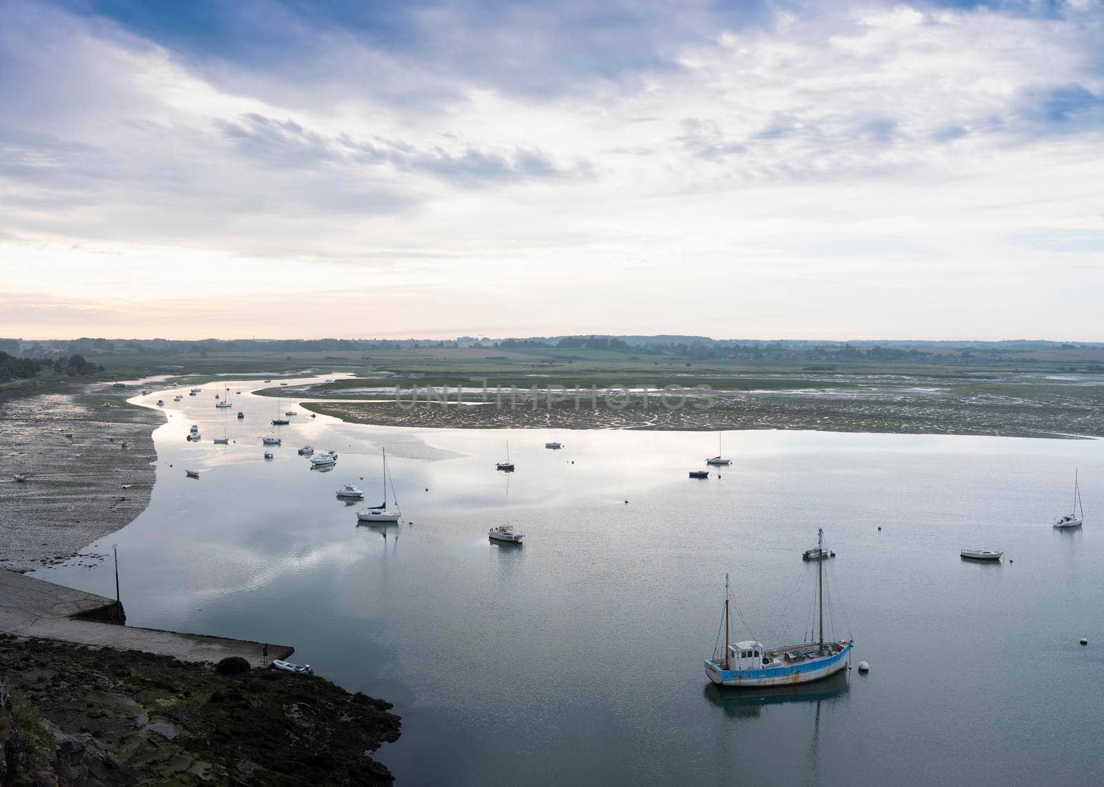 low tide and boats in river la rance in french region of brittany at sunrise in summer