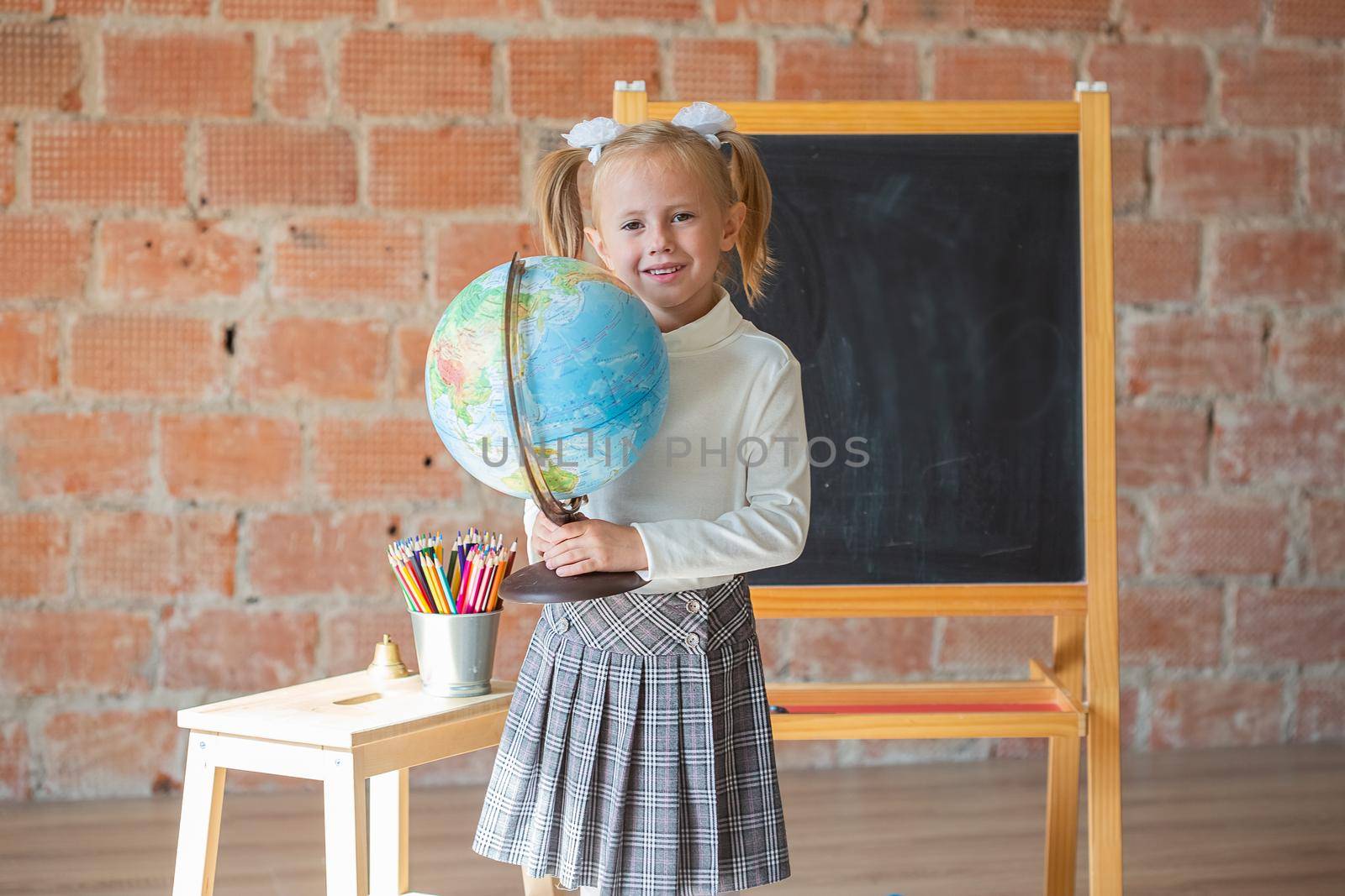 Portrait of caucasian schoolgirl with globe in her hands by galinasharapova