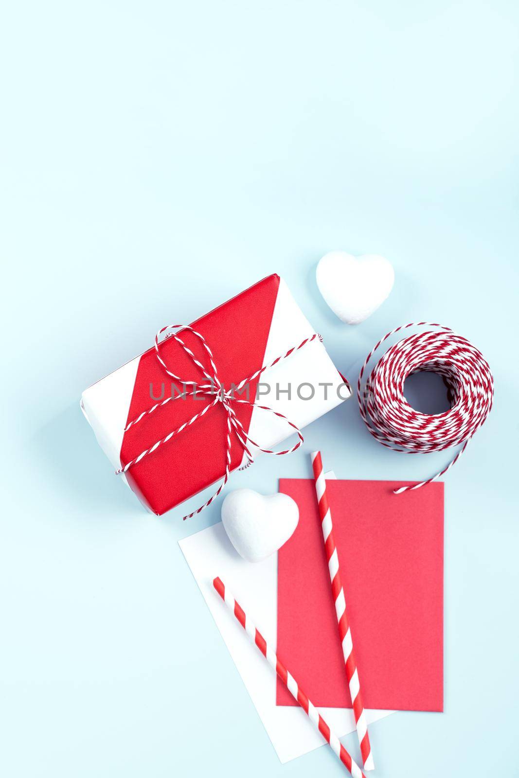 Mother's day, Valentine's Day handmade gift design concept - Wrapped gift box isolated on pastel light blue color background, flat lay, top view.