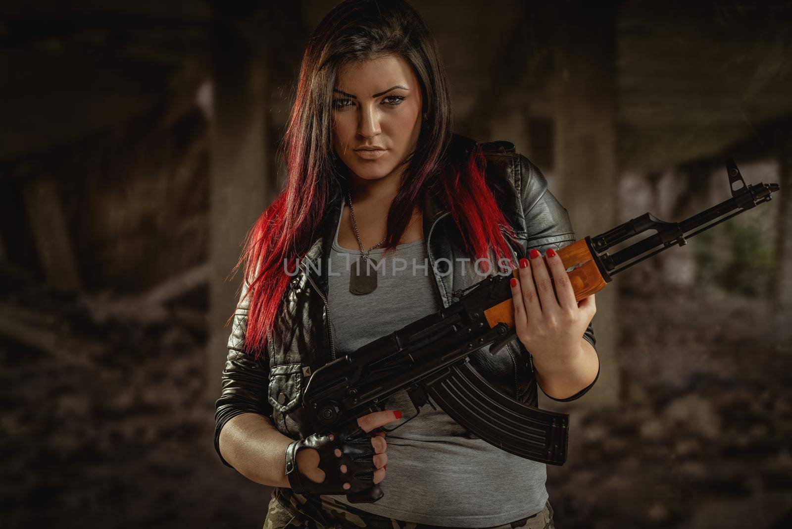 Young beautiful military woman holding rifle.