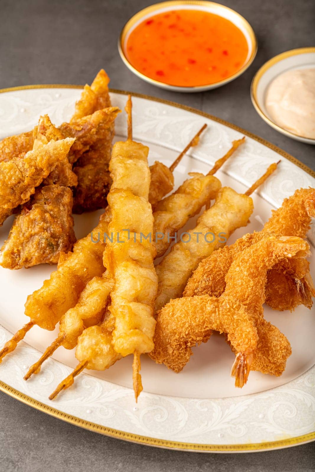 Seafood tempura with fish and shrimp on black stone table by Sonat