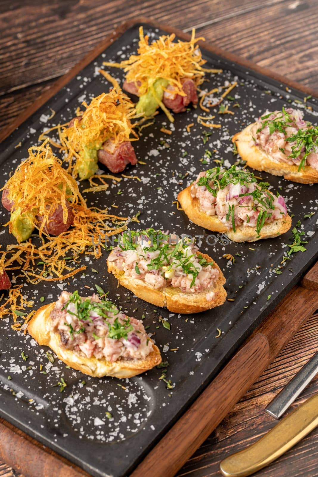 bruschetta with seafood made with Asian flavors on a stone cutting board by Sonat