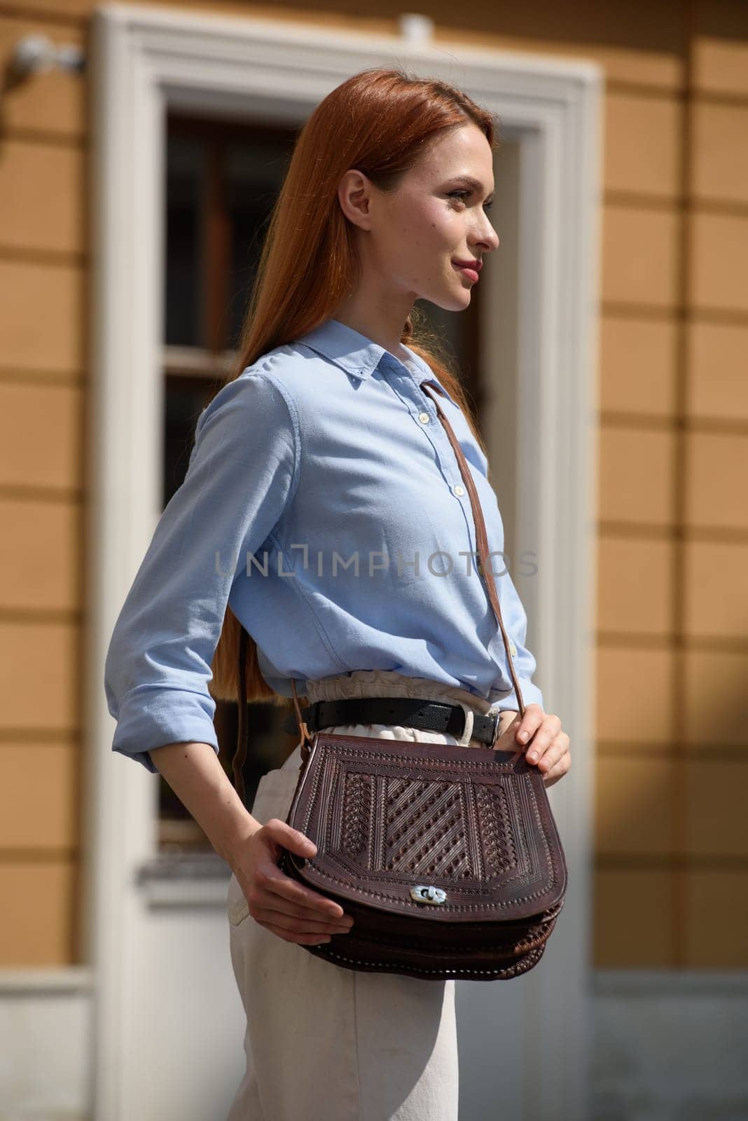 woman posing with a small brown leather bag with a carved pattern. by Ashtray25