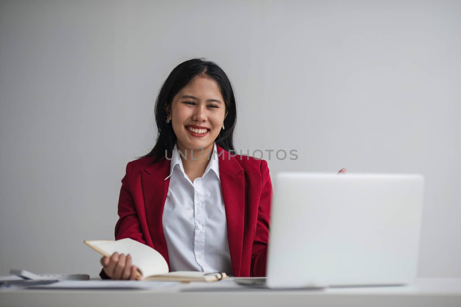 Cheerful business lady working on laptop in office, Asian happy beautiful businesswoman in formal suit work in workplace. Attractive female employee office worker smile. by wichayada