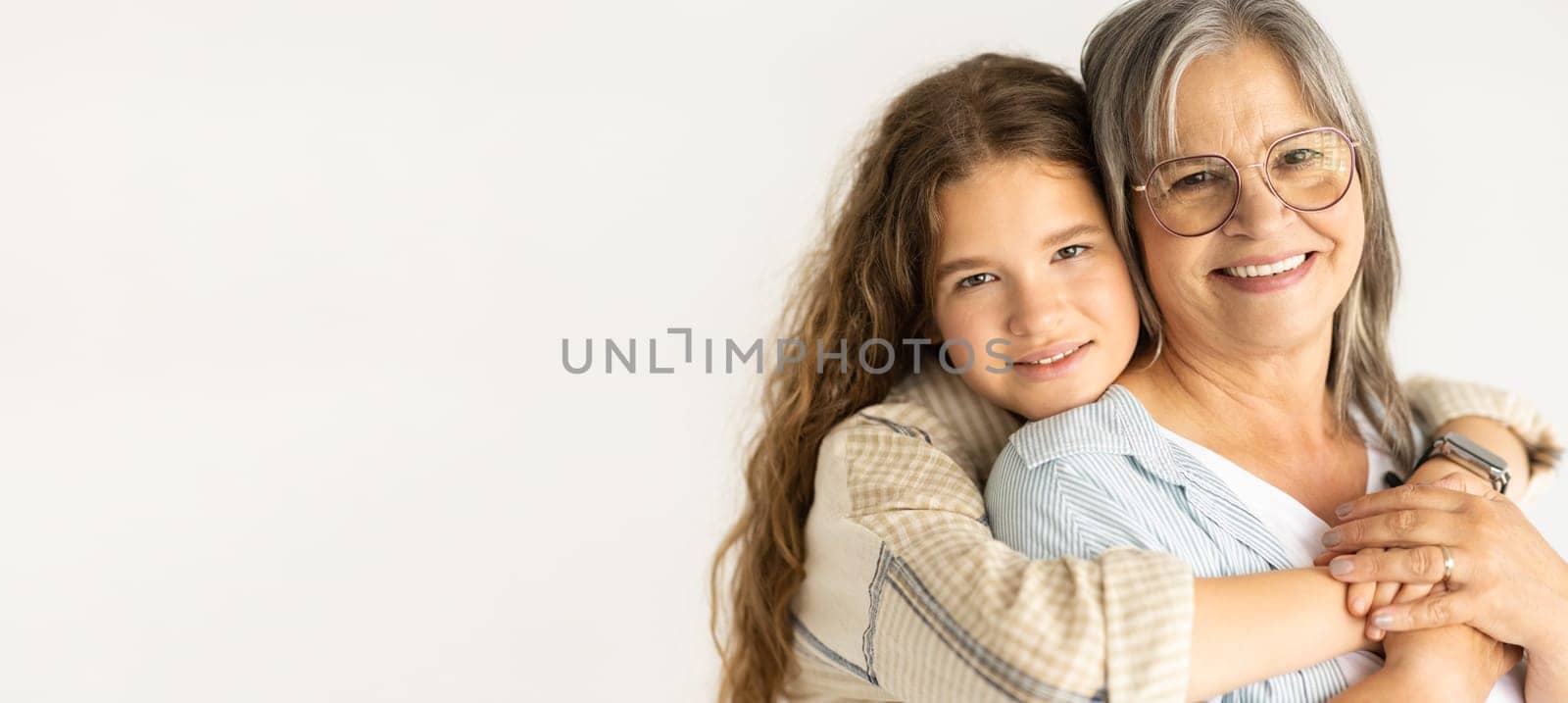 Happy european teen girl hugging old grandmother, enjoy support, isolated on white background, studio, panorama. Love, family relationships, female generation and genetic, beauty care