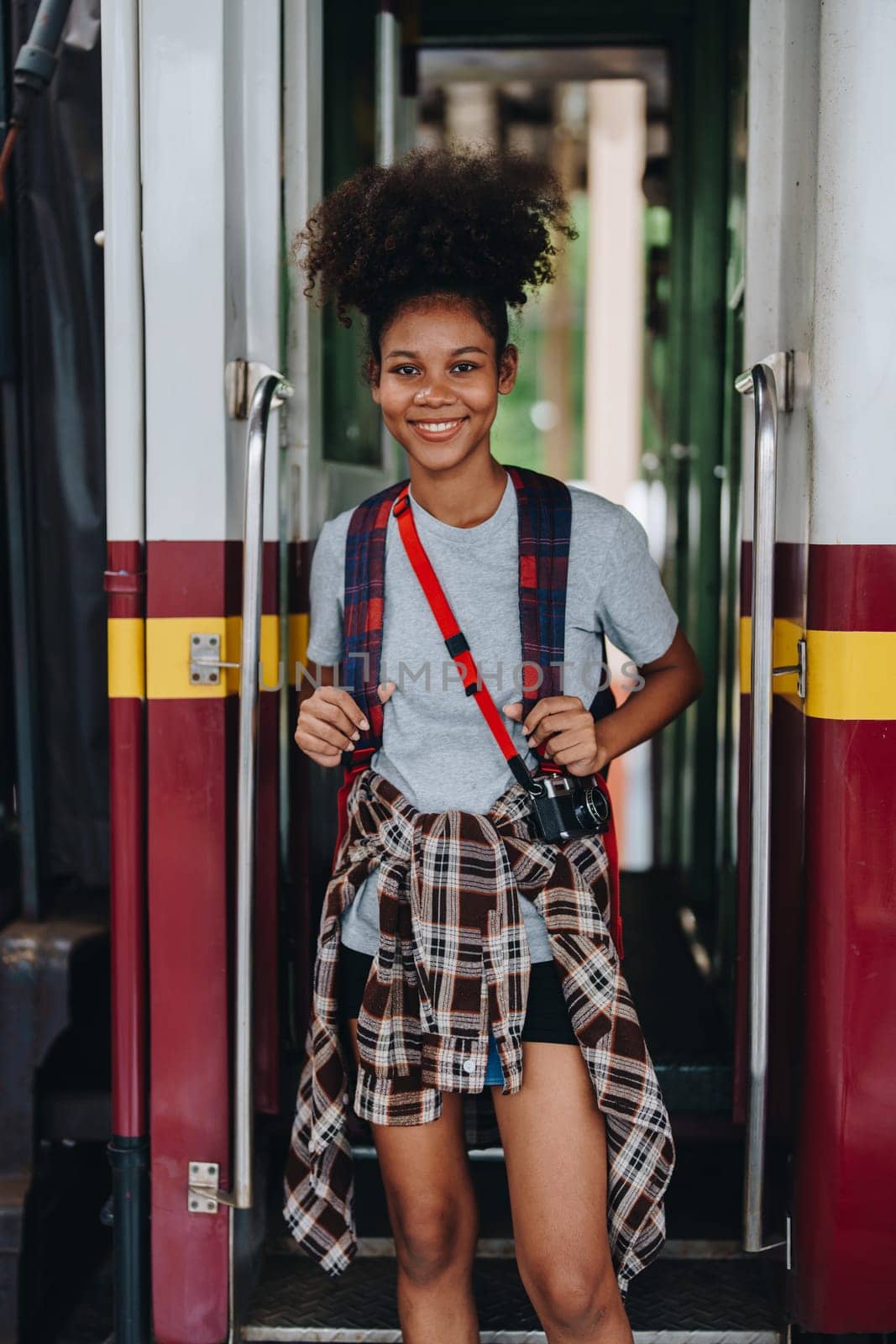 Tourists african american are showing happy expressions while waiting for their journey in the train station. by Manastrong