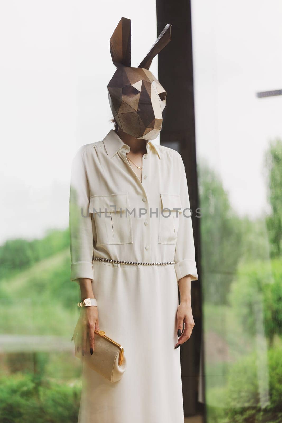 Fashionble woman in rabbit mask in the interior.