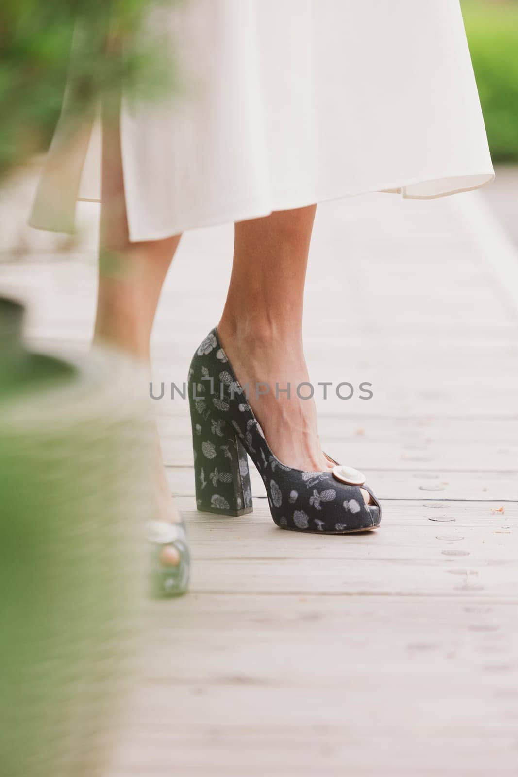 Close up of slim legs of woman wearing high heel shoes