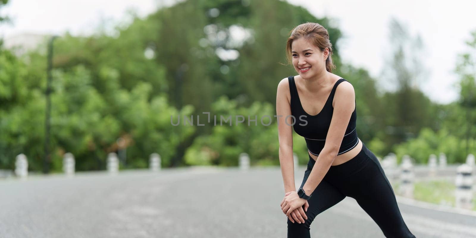 Healthy Asian woman is warm up before jogging. Fitness girl running. Female exercising at outdoor park.