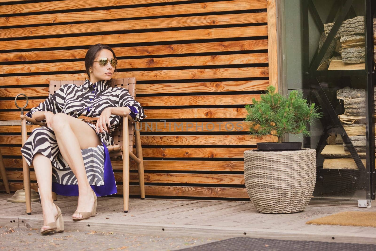 Beautiful girl relaxing on a resort. Woman in zebra dress sitting on chair by sarymsakov