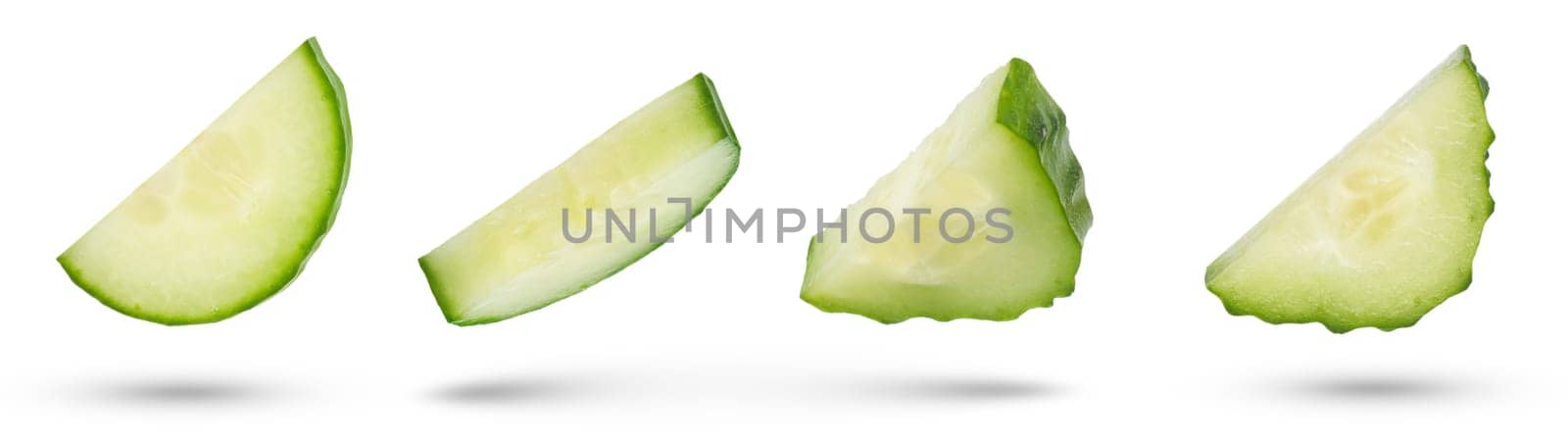 Slices of green cucumbers on a white isolated background. Cucumber slices hanging or falling on white. The concept of a delicious addition to a salad. High quality photo. by SERSOL