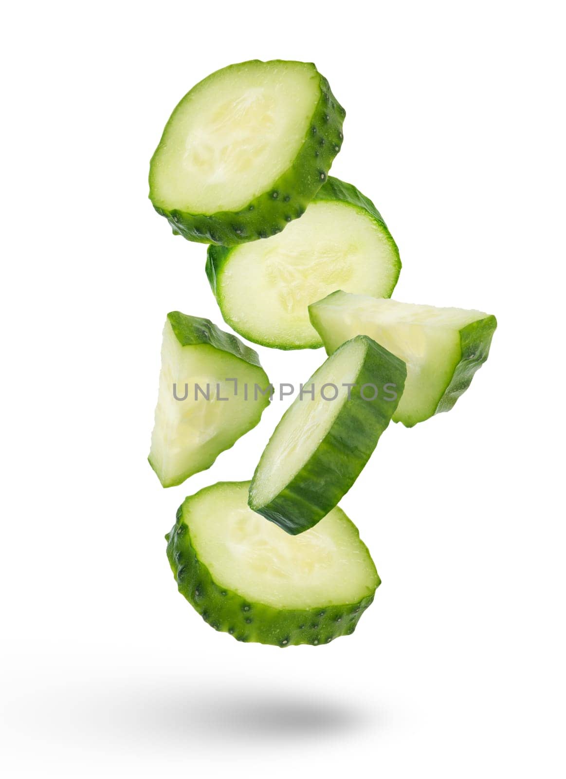 Slices of green cucumbers on a white isolated background. Slices of green cucumbers scatter in different directions. The concept of a delicious addition to a salad. by SERSOL