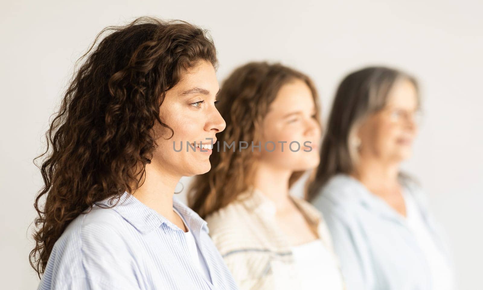Positive caucasian mature, old and teen woman and girl, profile, isolated on white background, studio. Beauty care, genetic and health care, family relationships, female generation