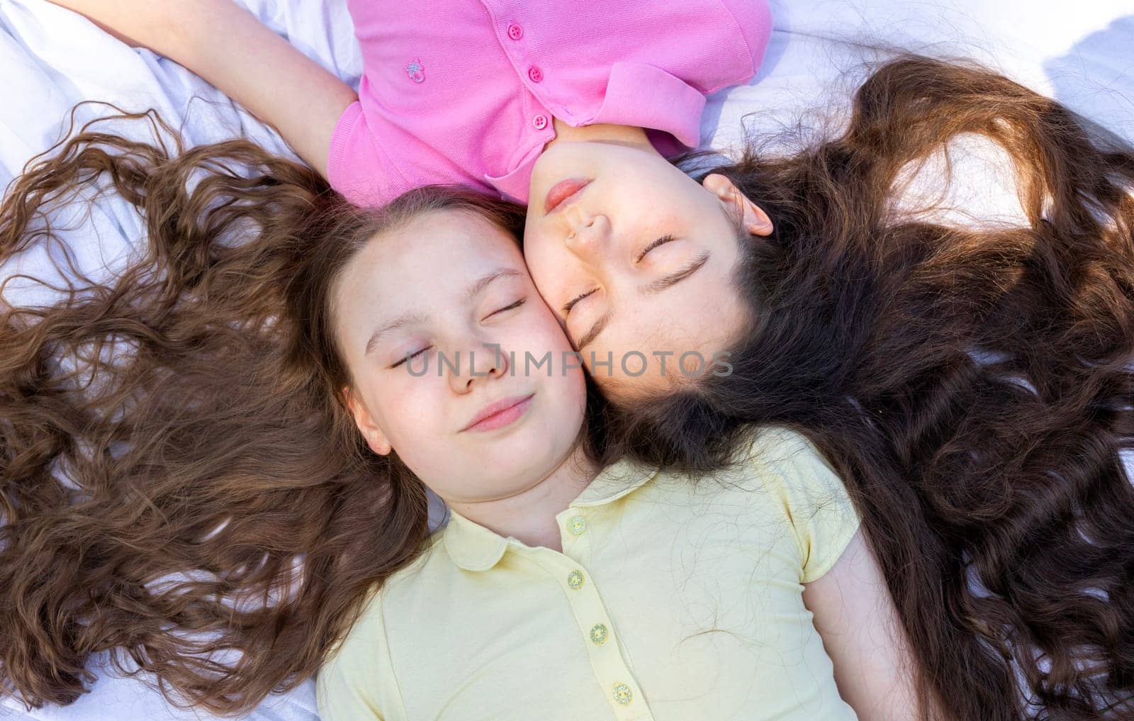 Top View Little Girls Lying On Plaid In Park, Meadow Under Sun, School Break Siblings Friendship, Having Fun In Nature. Horizontal Plane. High Quality Photo