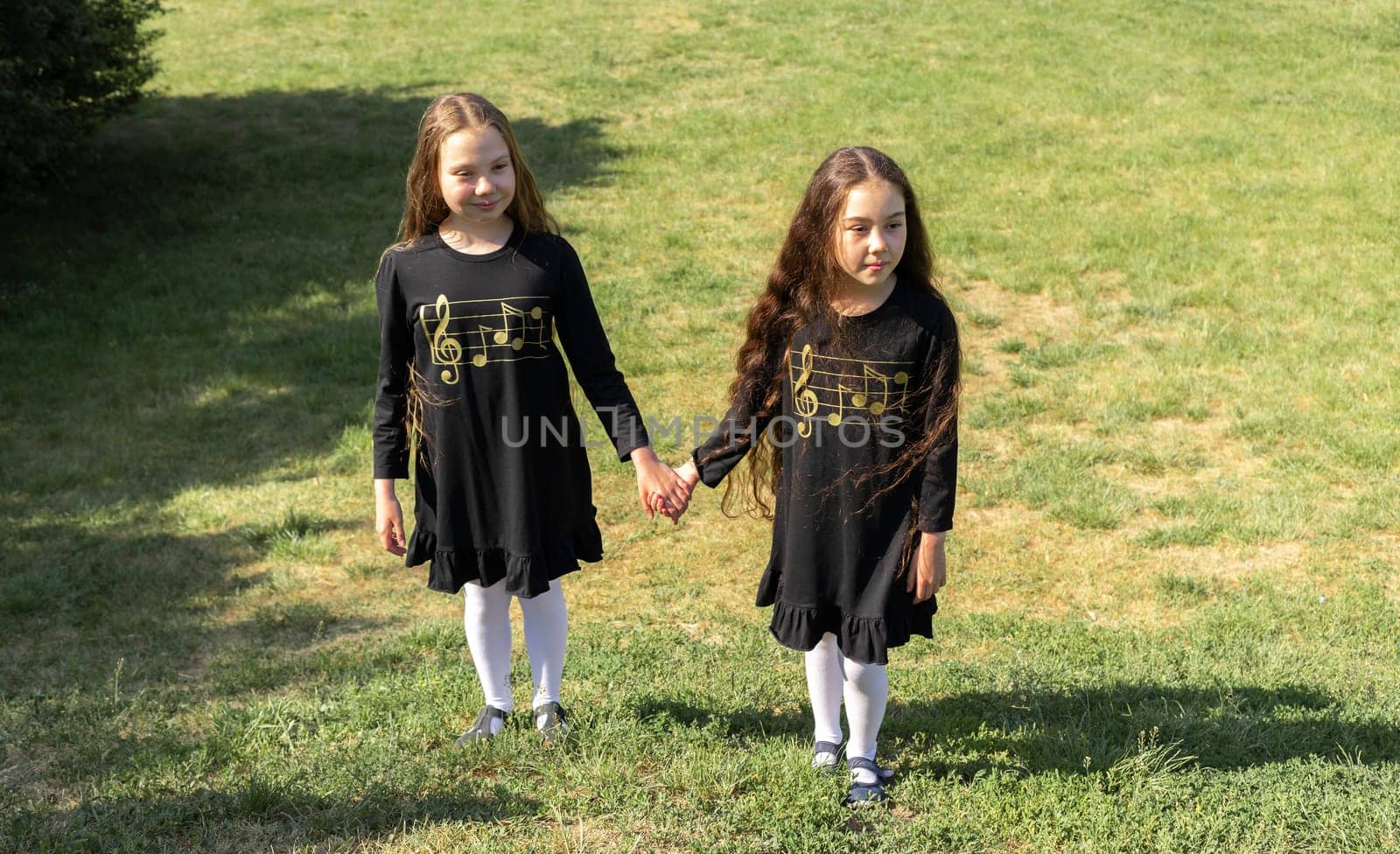 Little Girls, Children Enjoying Summer Time, School Break Walking Public Park At Sunny Day. Sisters Having Fun In Nature. True Friendship. Horizontal Plane. by netatsi