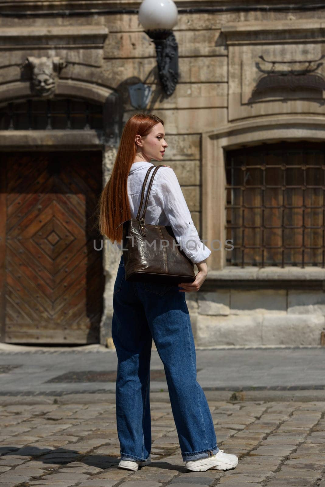 photo of a woman wearing blue jeans and white blouse with a brown leather handbag . by Ashtray25