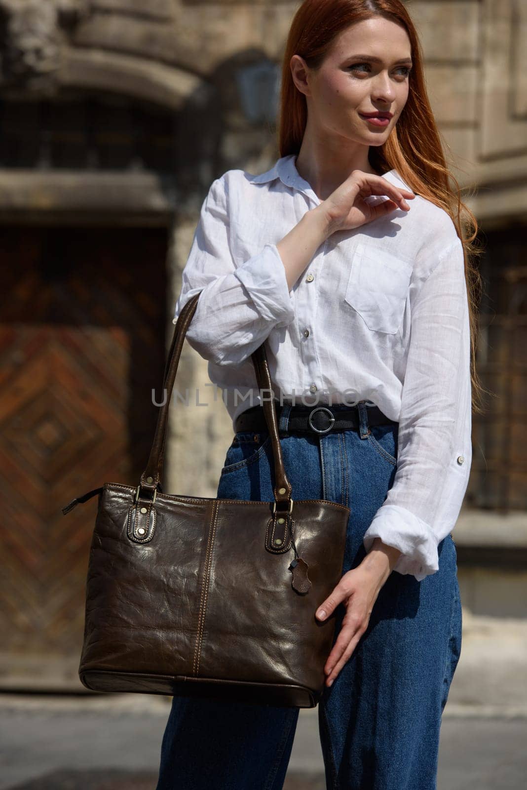 photo of a woman wearing blue jeans and white blouse with a brown leather handbag . by Ashtray25