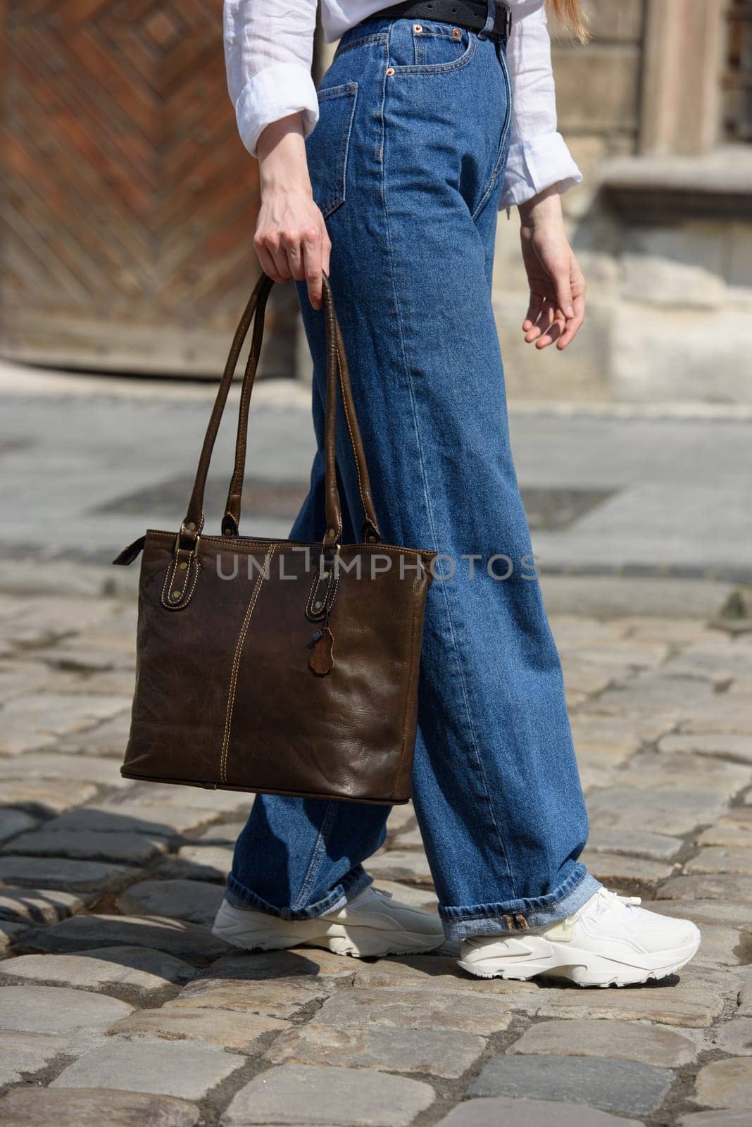 photo of a woman wearing blue jeans and white blouse with a brown leather handbag . by Ashtray25