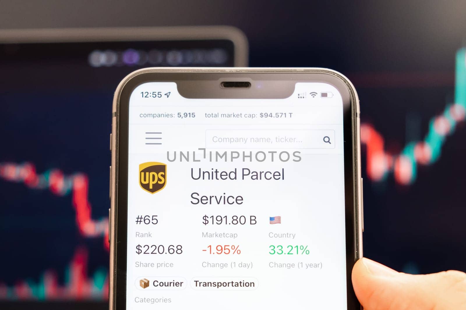 United Parcel Service stock price on the screen of cell phone in mans hand with changing stock market exchange with trading candlestick graph analysis, February 2022, San Francisco, USA