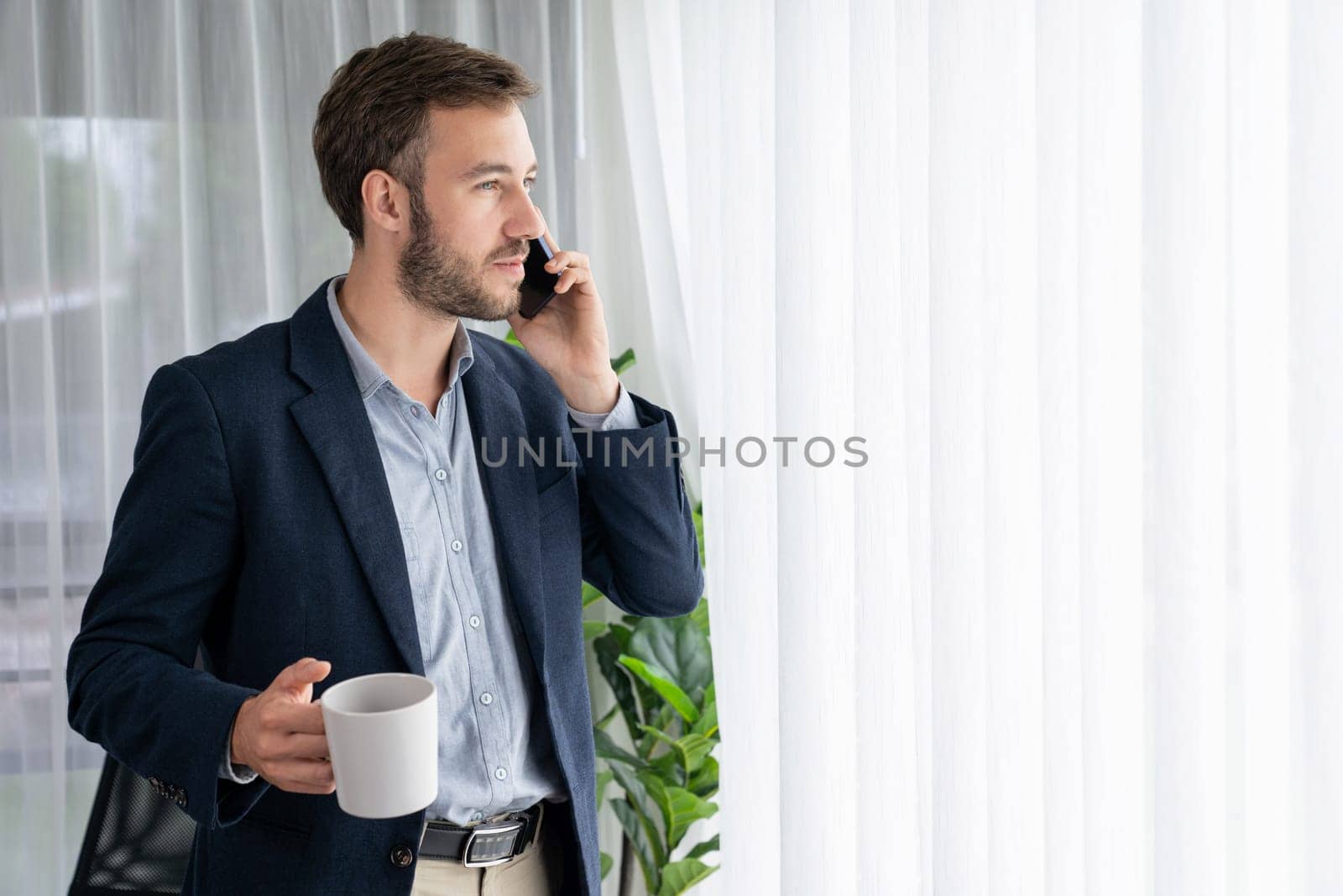 Hardworking businessman stand in modern office talking on phone. Entity by biancoblue