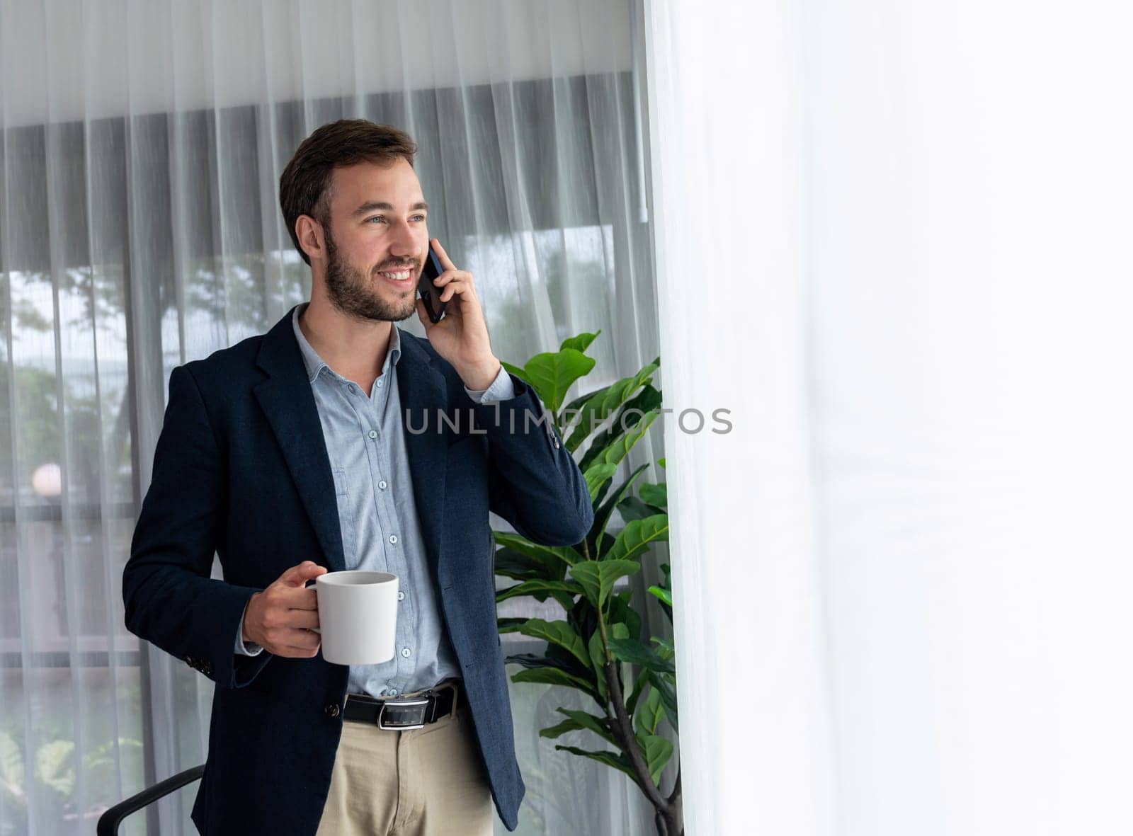 Hardworking businessman stand in modern office talking on phone. Entity by biancoblue