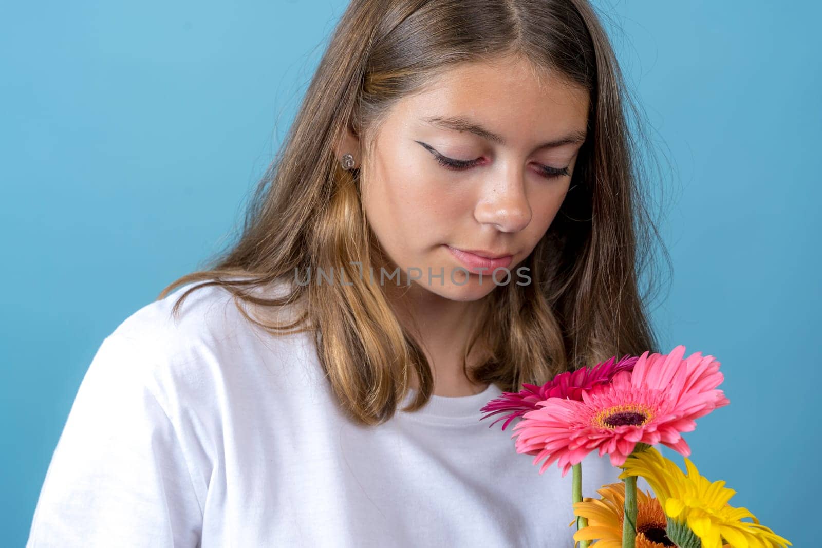 teenage girl who looks at the gerbera flowers that she holds in her hand by audiznam2609