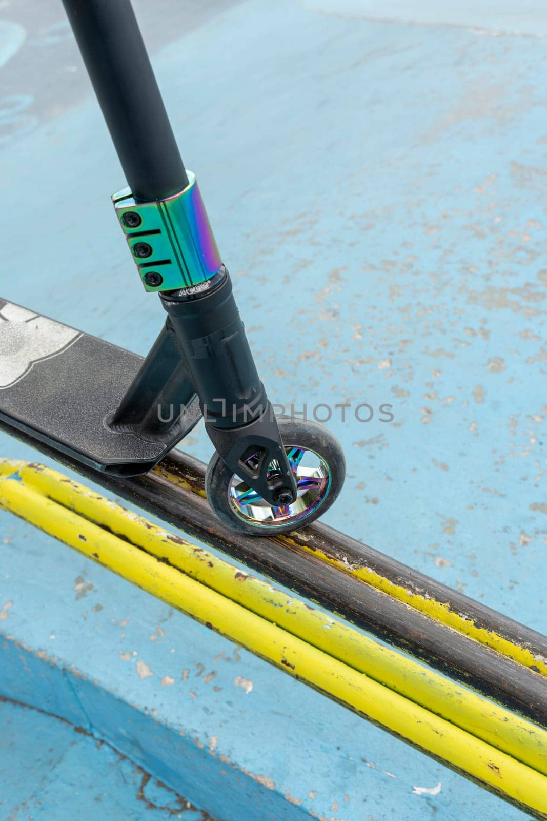 Stunt scooter on the yellow iron tube ramp of the skate park. Jumps and tricks. extreme urban outdoor sports, Healthy lifestyle concept. sports leisure. vertical photo