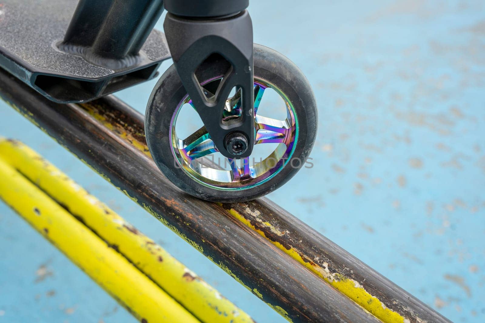 Stunt scooter on the yellow iron tube ramp of the skate park by audiznam2609