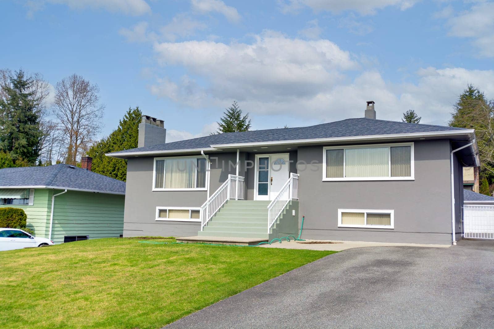 Average residential house with landscaped front yard. Modest tamily house in Canada