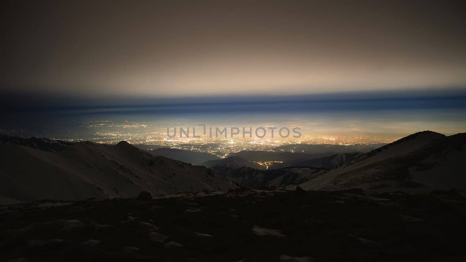 View of the night city from the snowy mountains by Passcal