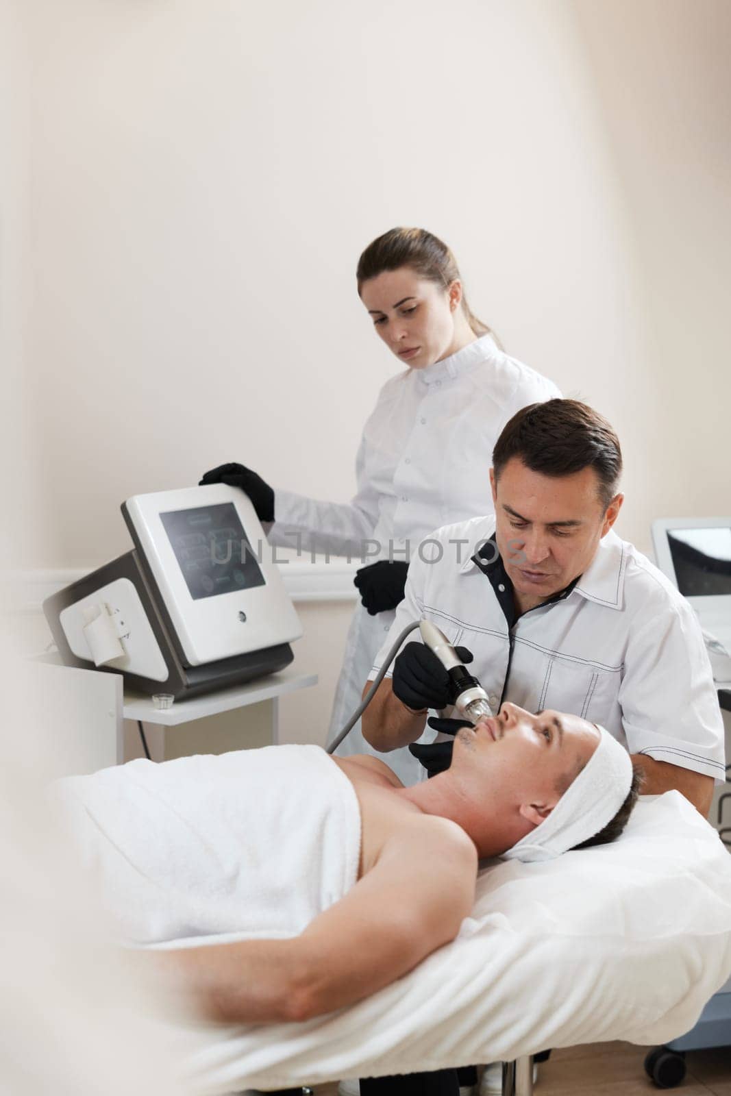 handsome man on RF lifting procedure in aesthetic medicine clinic