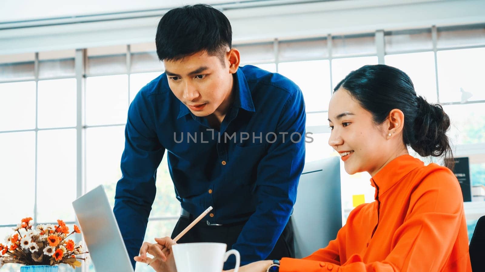 Two business people talk project strategy at office meeting room. Businessman discuss project planning with colleague at modern workplace while having conversation and advice on financial report. Jivy