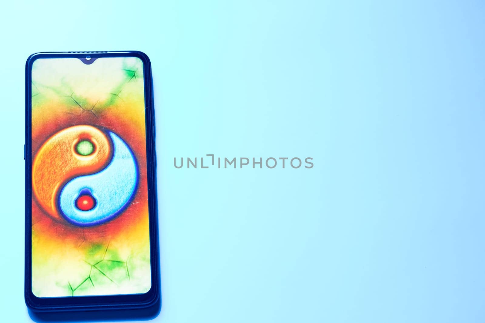 Mobile phone with a yin yang sign in a gentle blue background by jovani68
