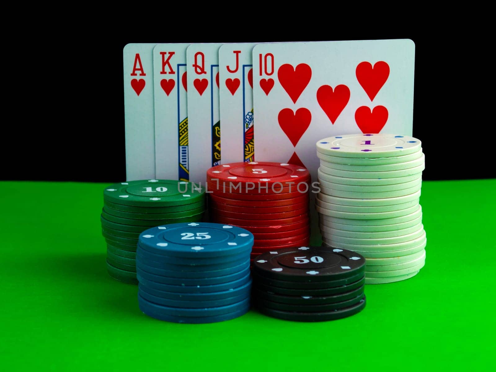 Royal flush cards and poker chips in stacks on the table. Cards on the table with a combination of royal flush and poker chips.