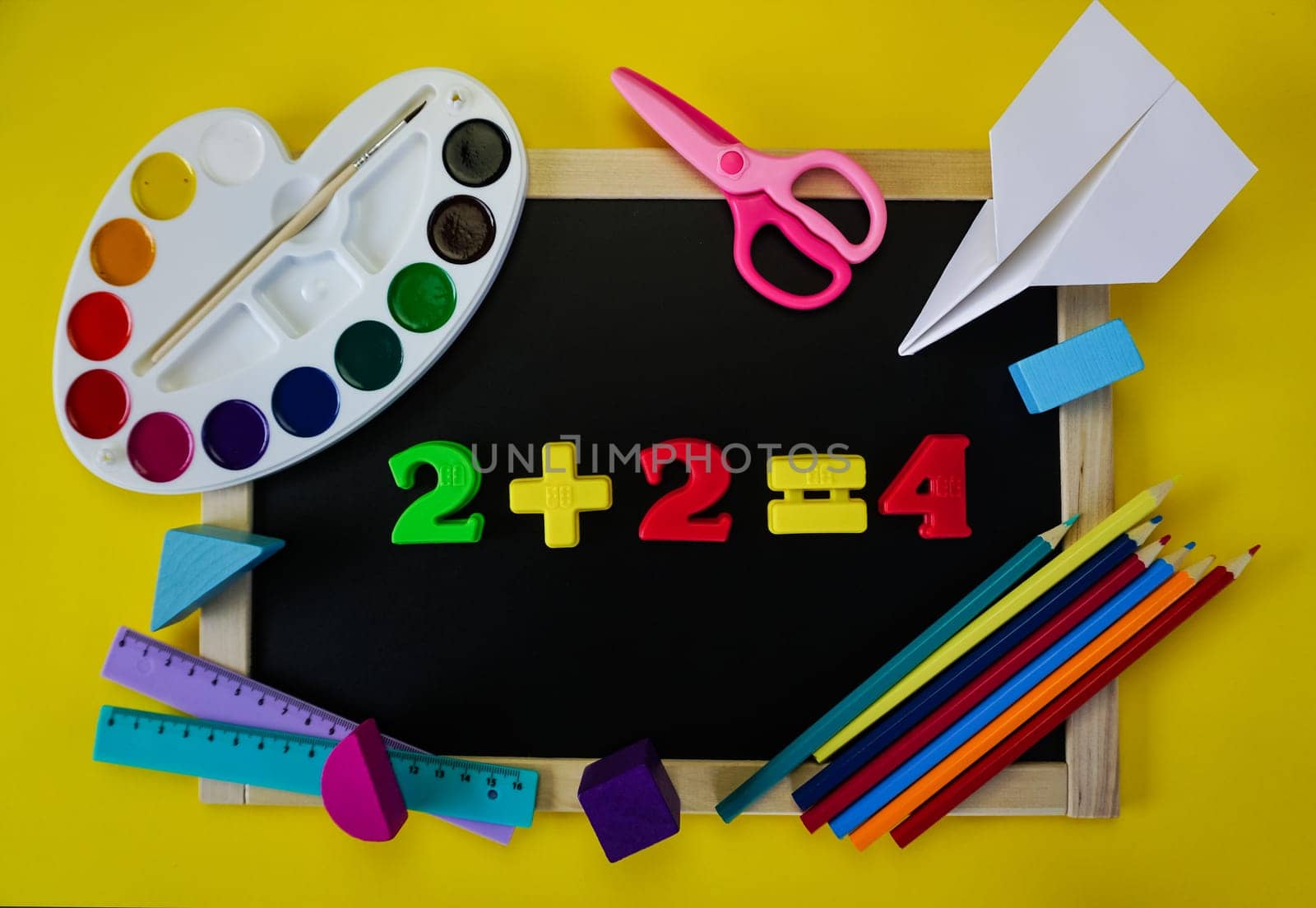 School supplies are laid out around the school chalkboard. The concept of returning to school. by Spirina