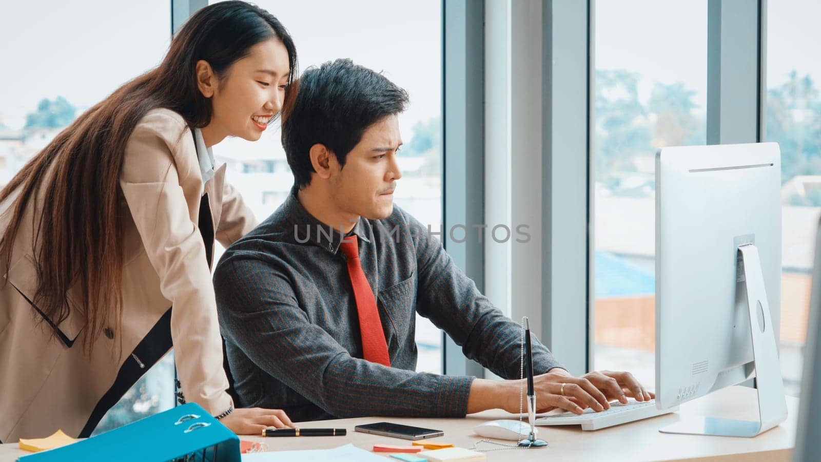 Two business people talk project strategy at office meeting room. Businessman discuss project planning with colleague at modern workplace while having conversation and advice on financial report. Jivy