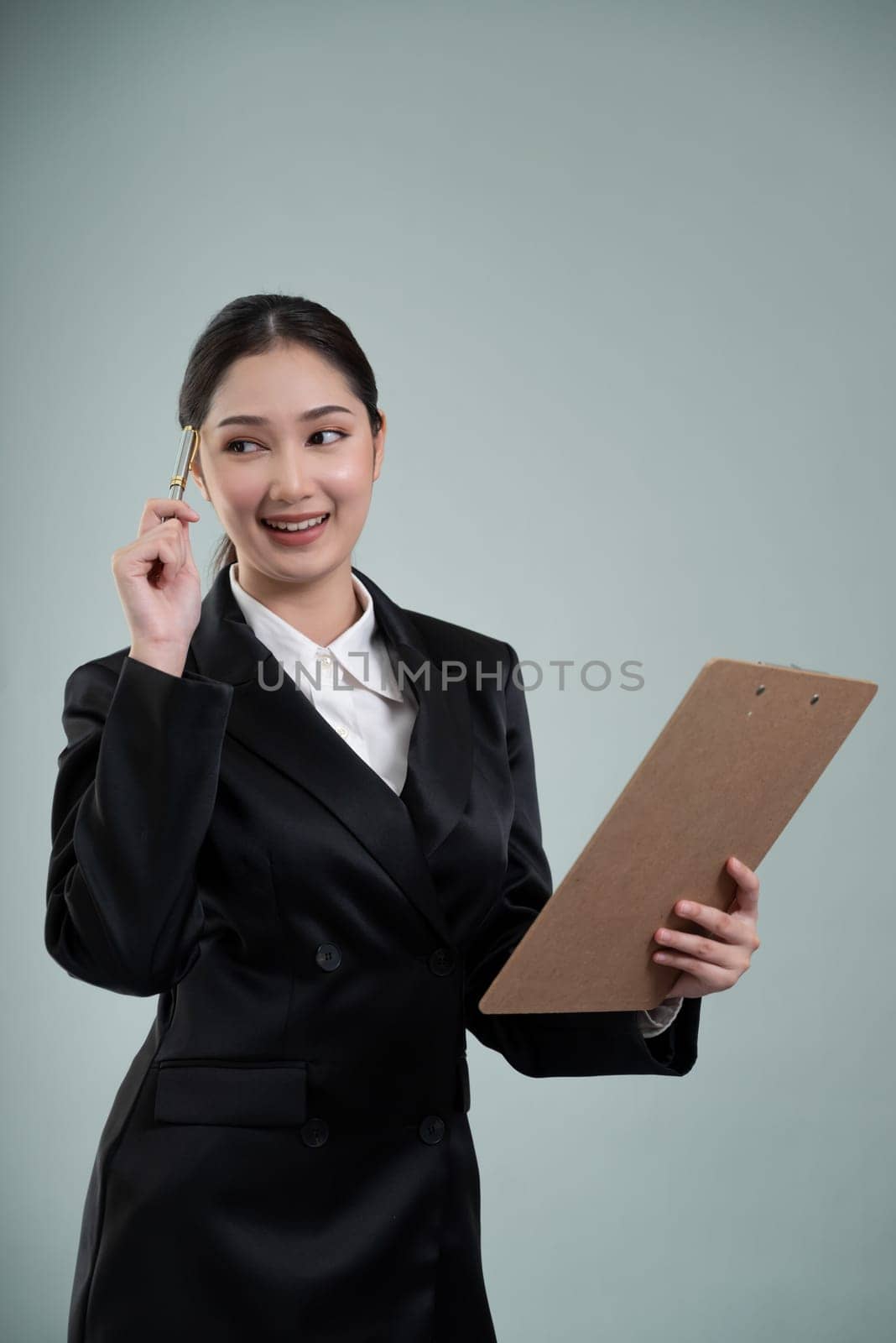 Confident young businesswoman stands on isolated background. Enthusiastic by biancoblue