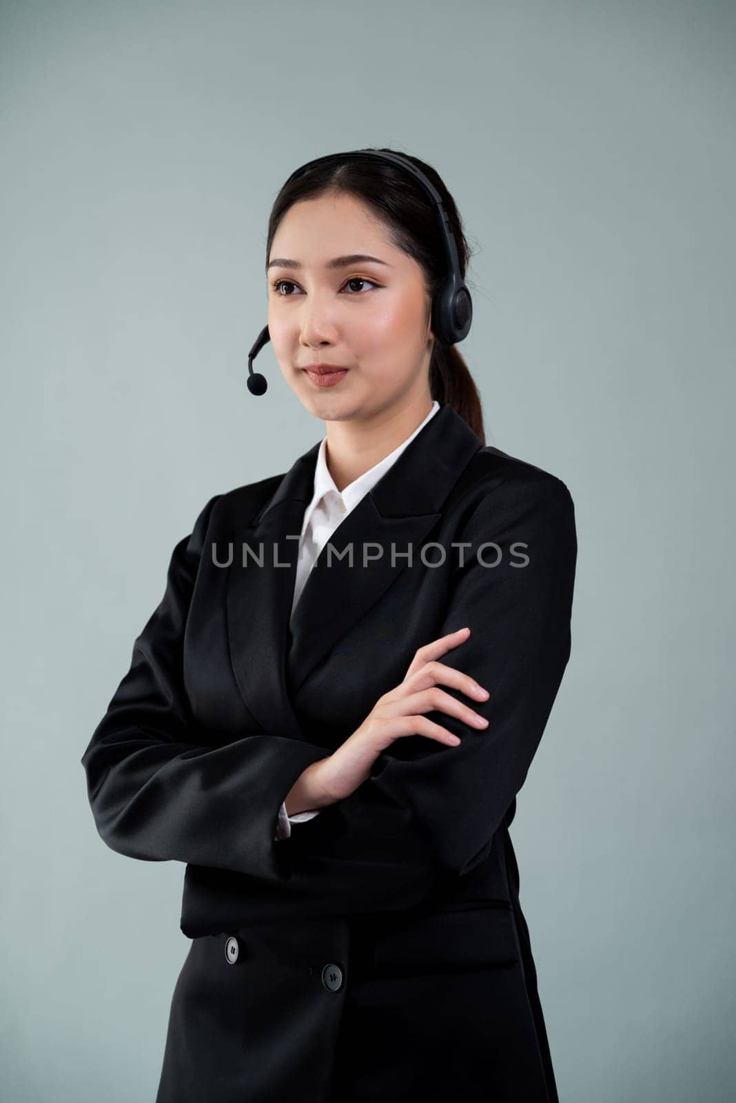 Attractive Asian operator with formal suit and headset. Enthusiastic by biancoblue