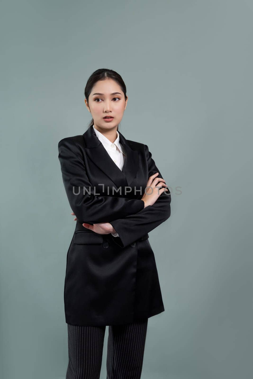 Confident young businesswoman stands on isolated background. Enthusiastic by biancoblue