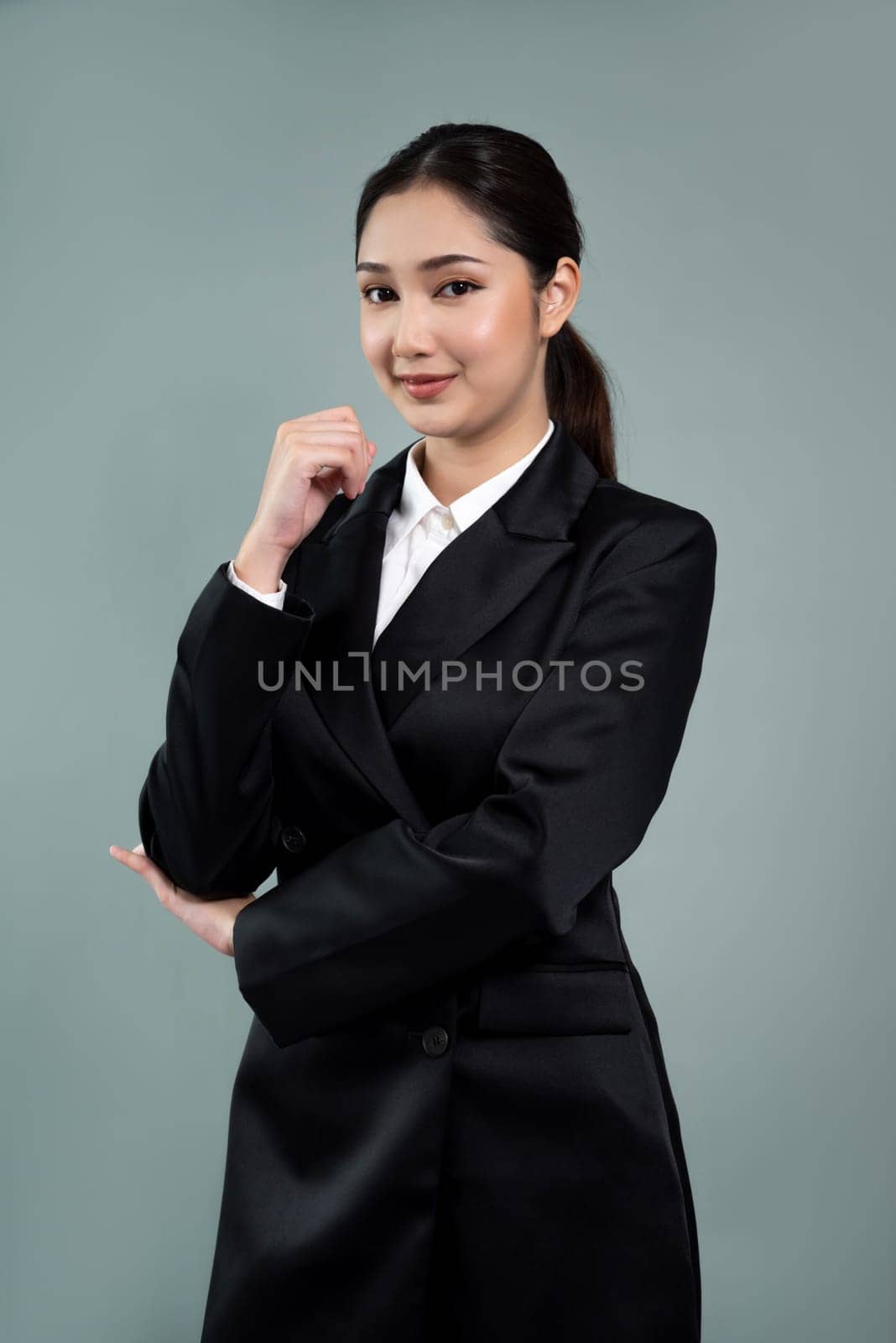 Confident young businesswoman stands on isolated background. Enthusiastic by biancoblue