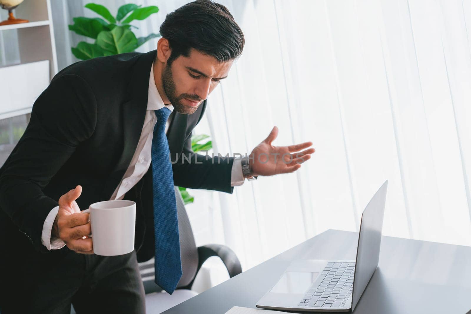 Professional businessman at modern office desk with confused expression, working on his laptop with disappointment and doubtful look. Struggle and challenging of office work. fervent