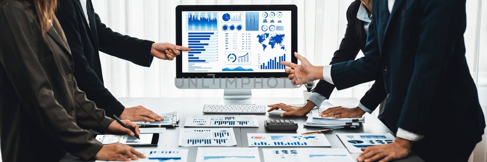 Panorama shot analyst team utilizing BI Fintech to analyze financial report with laptop. Businesspeople analyzing BI data dashboard displayed on laptop screen for business insight. Prodigy