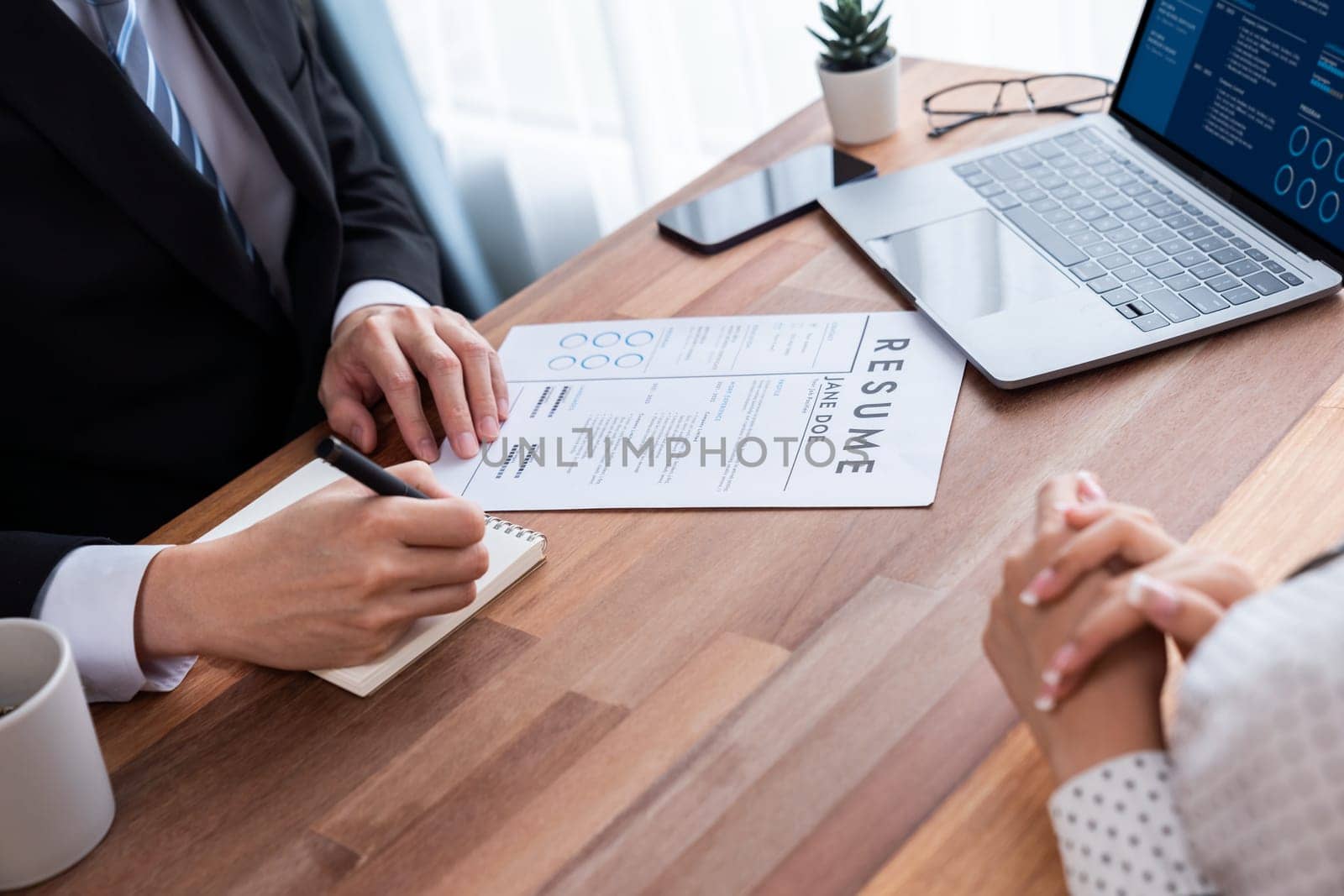 Conversational job interview between interviewer and candidate. Asian female job applicant present her performance and qualification by digital resume on laptop and CV paper to HR manager. Jubilant