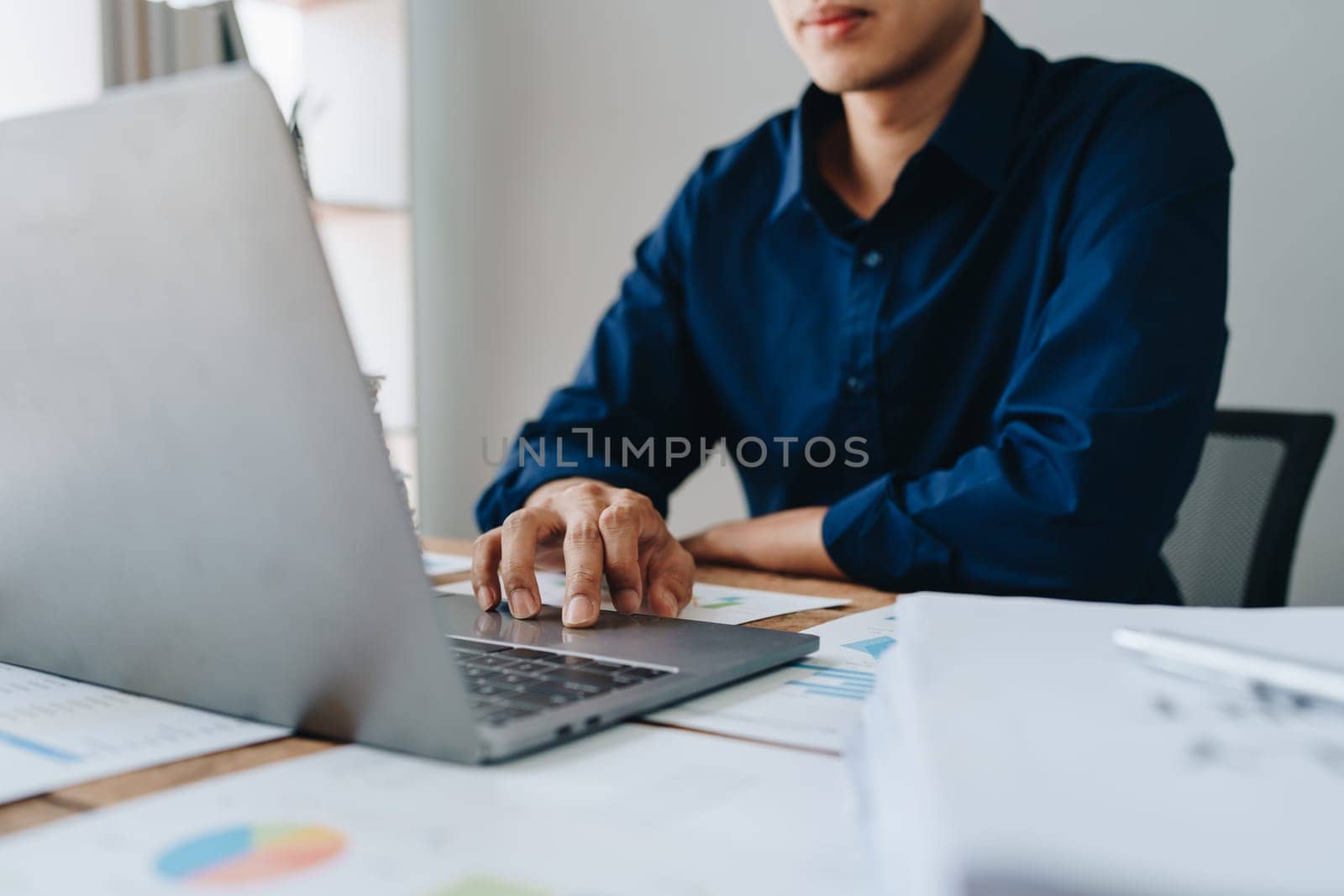 Businessman using computer laptop with planning working on financial document, tax, exchange, accounting and Financial advisor. by Manastrong